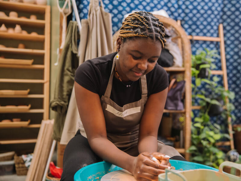 A teenage girl smiling at a pottery class